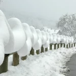 Glissière bordant une route de Cervens recouverte d’une épaisse couche de neige