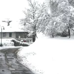 Chemin de Cervens bordé de maisons et d’arbres chargés de neige